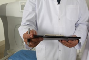 Lekarz trzymający dokumenty i długopis w rękach